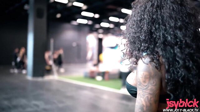 Curvy black fit girl with huge tits and tats teases at gym event