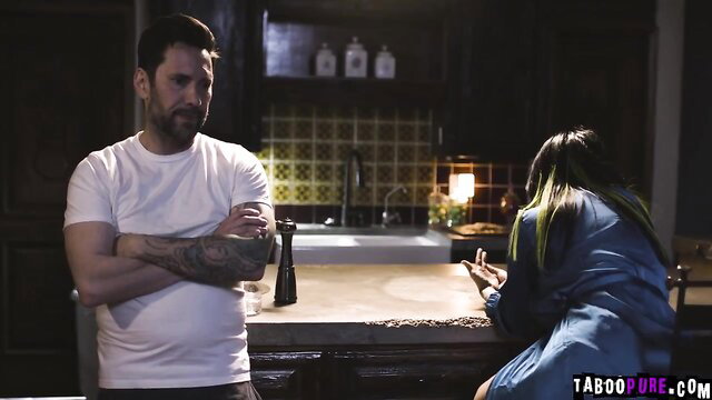 Bearded man in kitchen confronts Asian woman with green hair