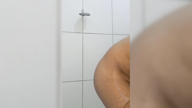 Curvy Latina woman washing her wet nude body in steamy shower