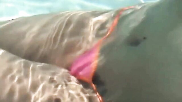 Sexy brunette in pink thong bikini, wet curves in pool solo tease