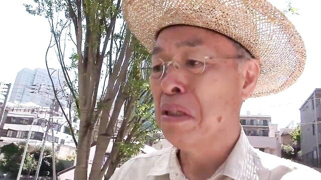 Japanese father-in-law in straw hat eyeing daughter-in-law outdoors