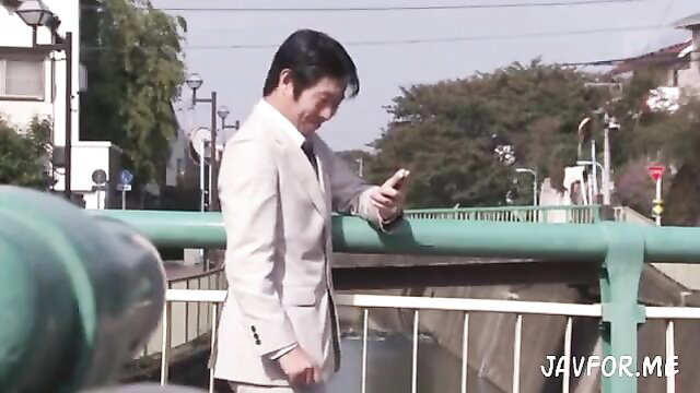 Handsome Japanese man in white suit checking phone on bridge, JAV style