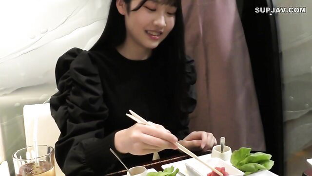 Asian JAV girl with long black hair eating with chopsticks, smiling cutely