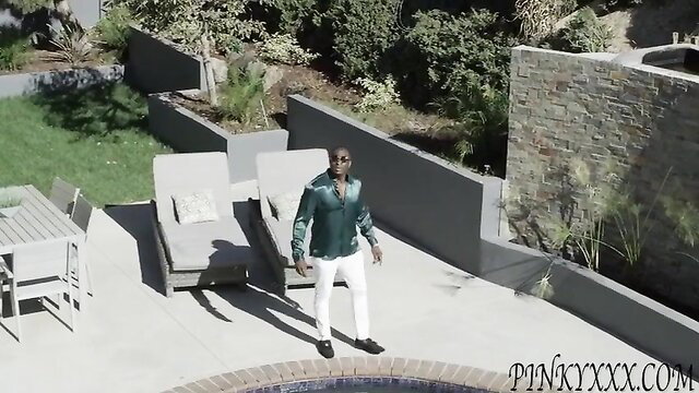 Handsome Black man in green silk shirt and white pants on patio