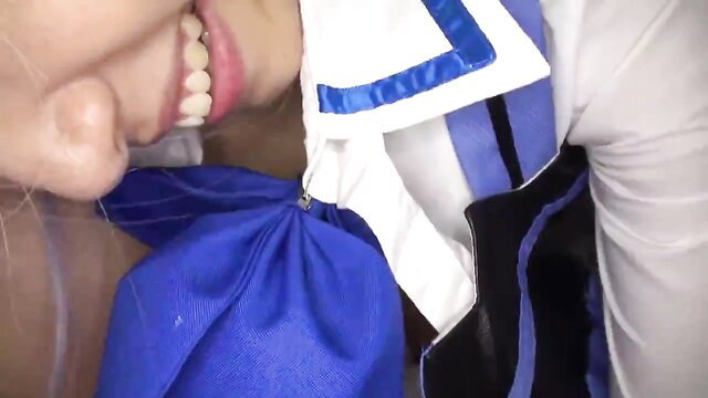 Japanese cosplay girl smiling with blue bowtie, closeup oral tease