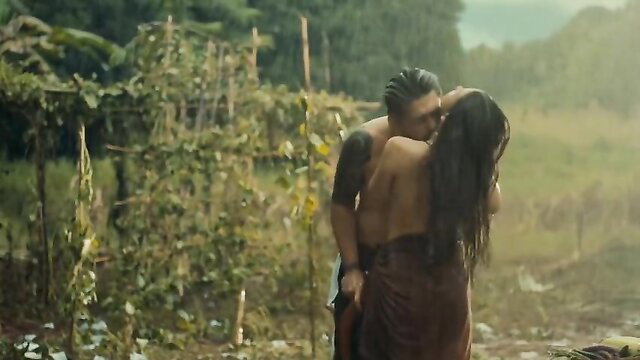 Passionate outdoor kiss between tattooed Asian hunk and wet Filipina beauty