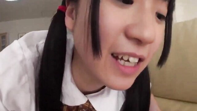 Cute Japanese schoolgirl with pigtails smiling closeup