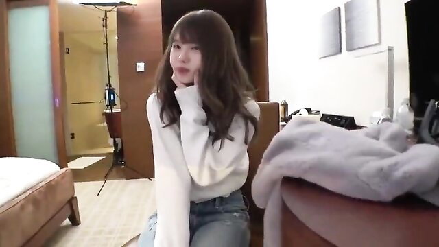 Asian beauty with bangs in white sweater and jeans, cute finger to lips pose