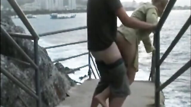 Amateur Asian couple fucking outdoors on seaside railing