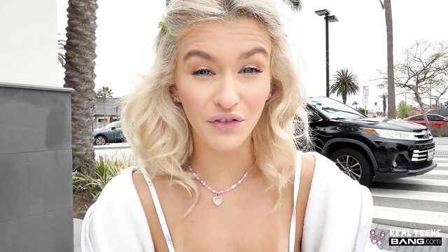 Emma Rosie blonde teen in open white top showing cleavage outdoors