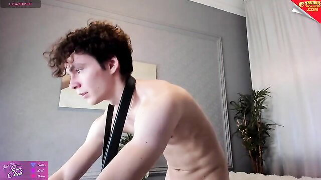Nude curly-haired twink camboy in leather collar on cam show