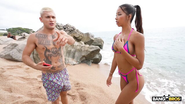 Lia Lin in tiny pink bikini on beach with tattooed stud