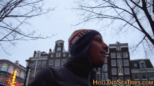 Outdoor Amsterdam escort in beanie and jacket on sex trip