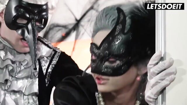 Masked stepdaughter in black gown grabs masked man in Halloween tease