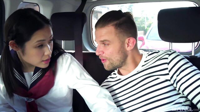 Asian schoolgirl in car leans close to handsome guy with huge bulge