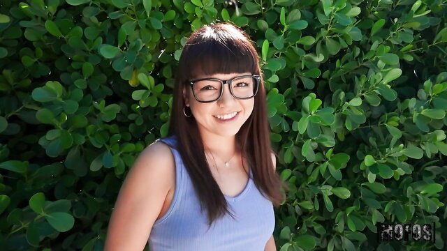 Mochi Mona smiles seductively in tank top and glasses outdoors