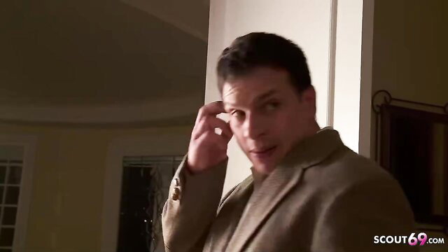 Handsome suited man smirking in dimly lit room, parody roleplay tease