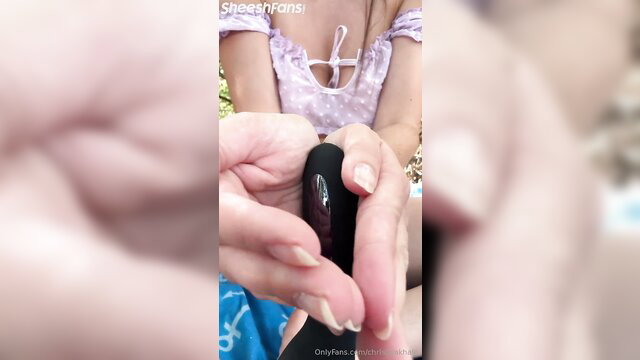 Christina Khalil holding black dildo closeup in tight pink top OnlyFans