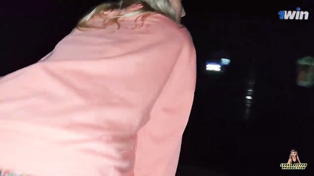 Blonde amateur in pink hoodie flashes ass at night railway station
