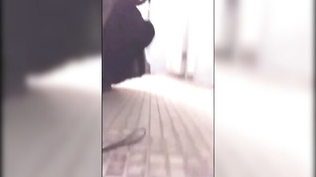 Blurry Chinese crossdresser in dark dress stands on brick floor