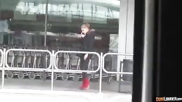 Blonde with huge natural tits in black coat and red boots at airport