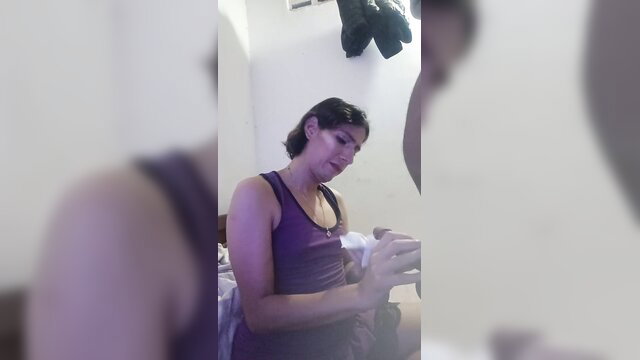 Blurry brunette amateur femboy in purple tank top holding object close-up