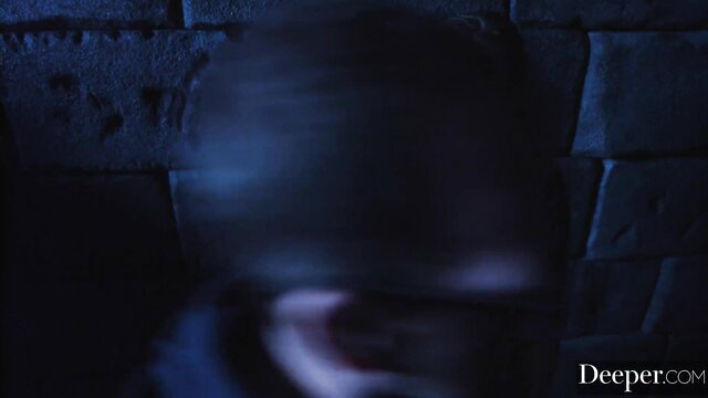 Blurry dark figure against stone wall in steamy adult scene