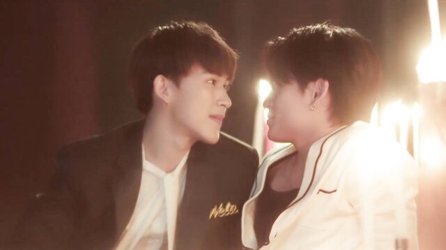 Two handsome Asian guys in suits gazing intimately in boys love scene