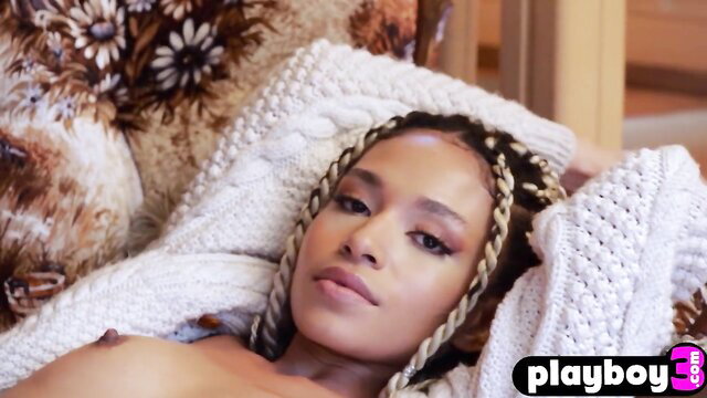 Petite black mom with braids lounging topless in white sweater
