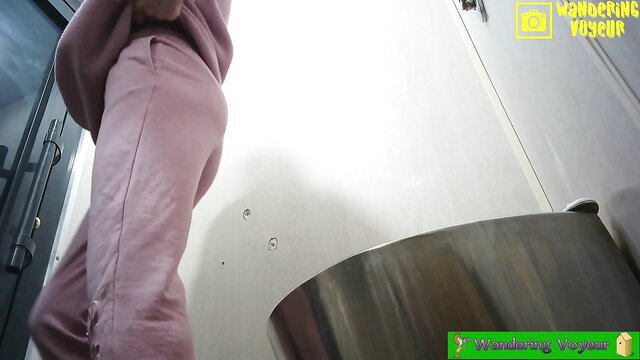 Amateur Asian woman in pink sweats bending over public toilet urinal spy cam
