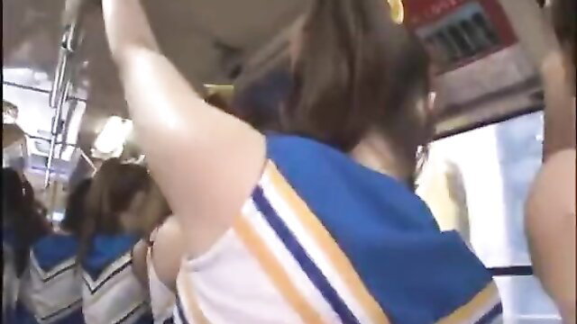 Japanese cheerleaders in tight uniforms on crowded bus