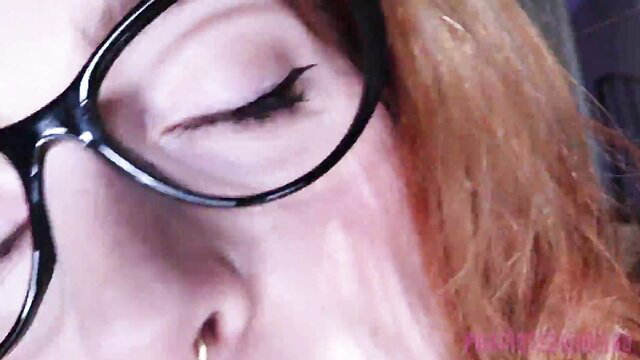 Closeup POV of sexy redhead with glasses, seductive eyes and glossy lips