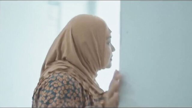 Beige hijab Muslim woman leaning against wall in erotic Vivamax scene