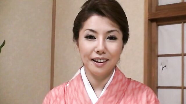 Japanese beauty in pink kimono smiles seductively close-up