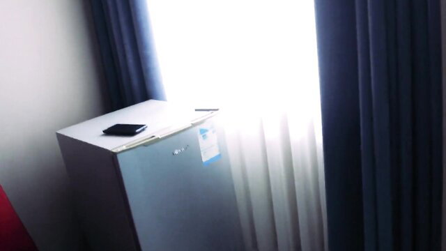 Diana Rider next to mini fridge in hotel room