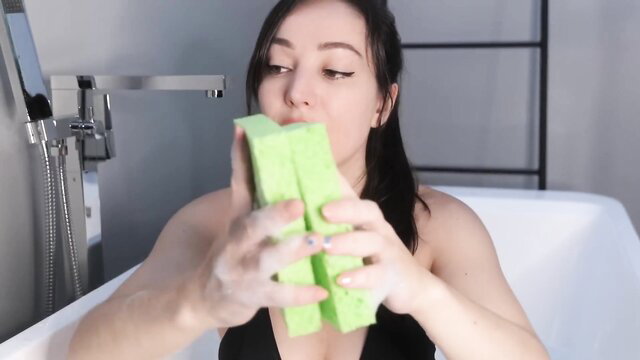 Asian GF Orenda ASMR in black lingerie holding wet green sponges in bath