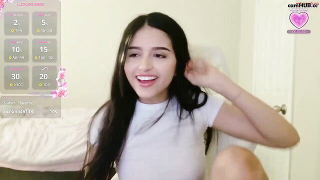 Elisparadisex smiling on Chaturbate, long black hair, white tee tease
