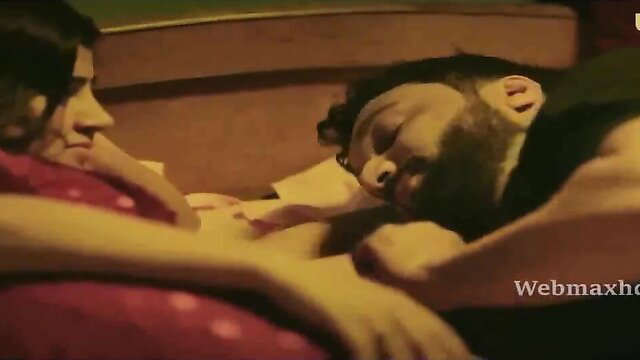 Indian couple in bed, busty brunette cuddling bearded man asleep