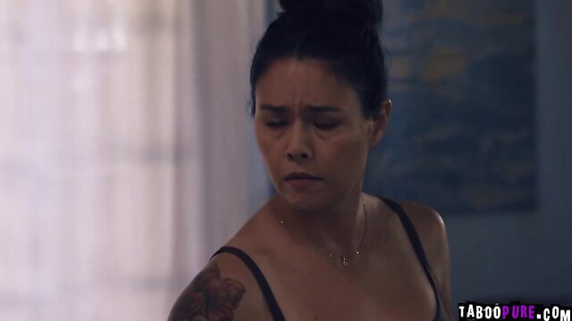 Tattooed brunette in tank top looks emotional in taboo scene
