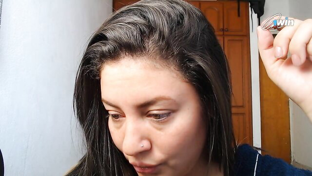 Closeup of pretty Latina woman with long dark hair holding clip, intro pose