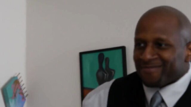 Jada Fire smiling in suit, black busty MILF thumbnail