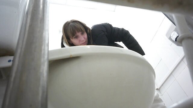 Amateur hidden cam spy of young brunette peeking from public toilet stall