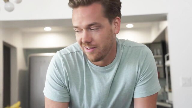 Handsome young man smiling in kitchen, teasing wild stepsister passion