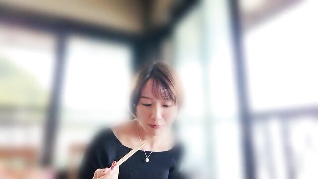 Japanese mature woman in black dress holding chopsticks close-up