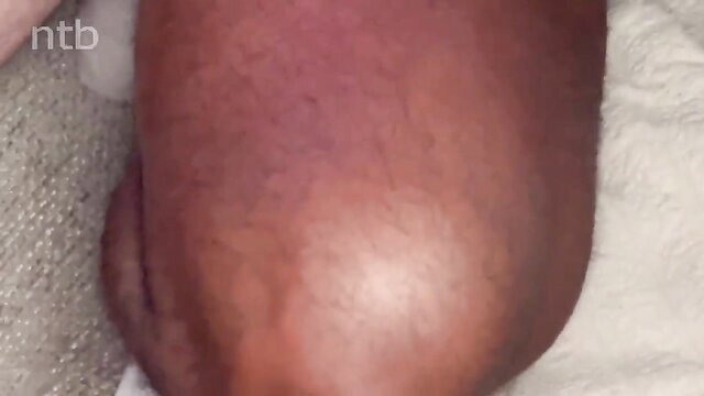 Closeup of black woman's thick thighs and pussy on white sheets