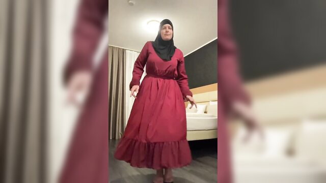 Fatima in red hijab dress dancing seductively in hotel room