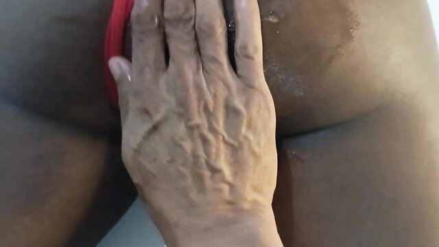 Ebony babe's oiled big ass spread wide, red thong pulled aside for anal tease