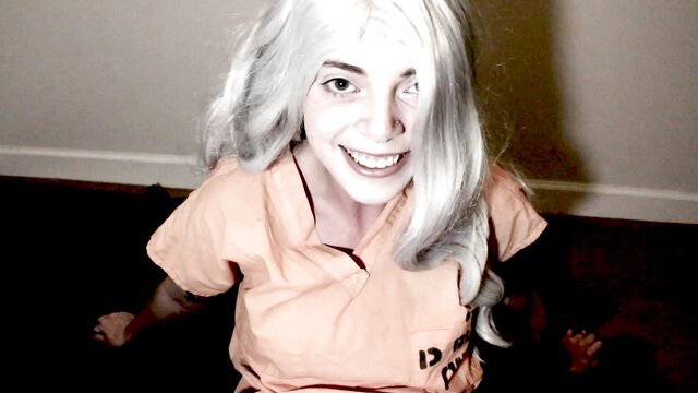 Ivywolf as Harley Quinn in orange prison jumpsuit, smiling seductively
