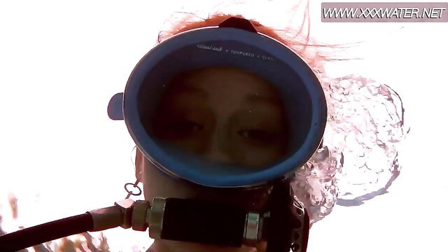 Asian girl in blue scuba mask with red hair underwater, sexy dive tease