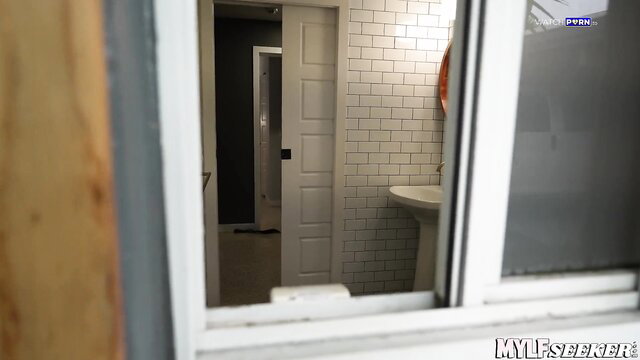 Sydney Paige in tiled bathroom, topless with big tits, looking through window